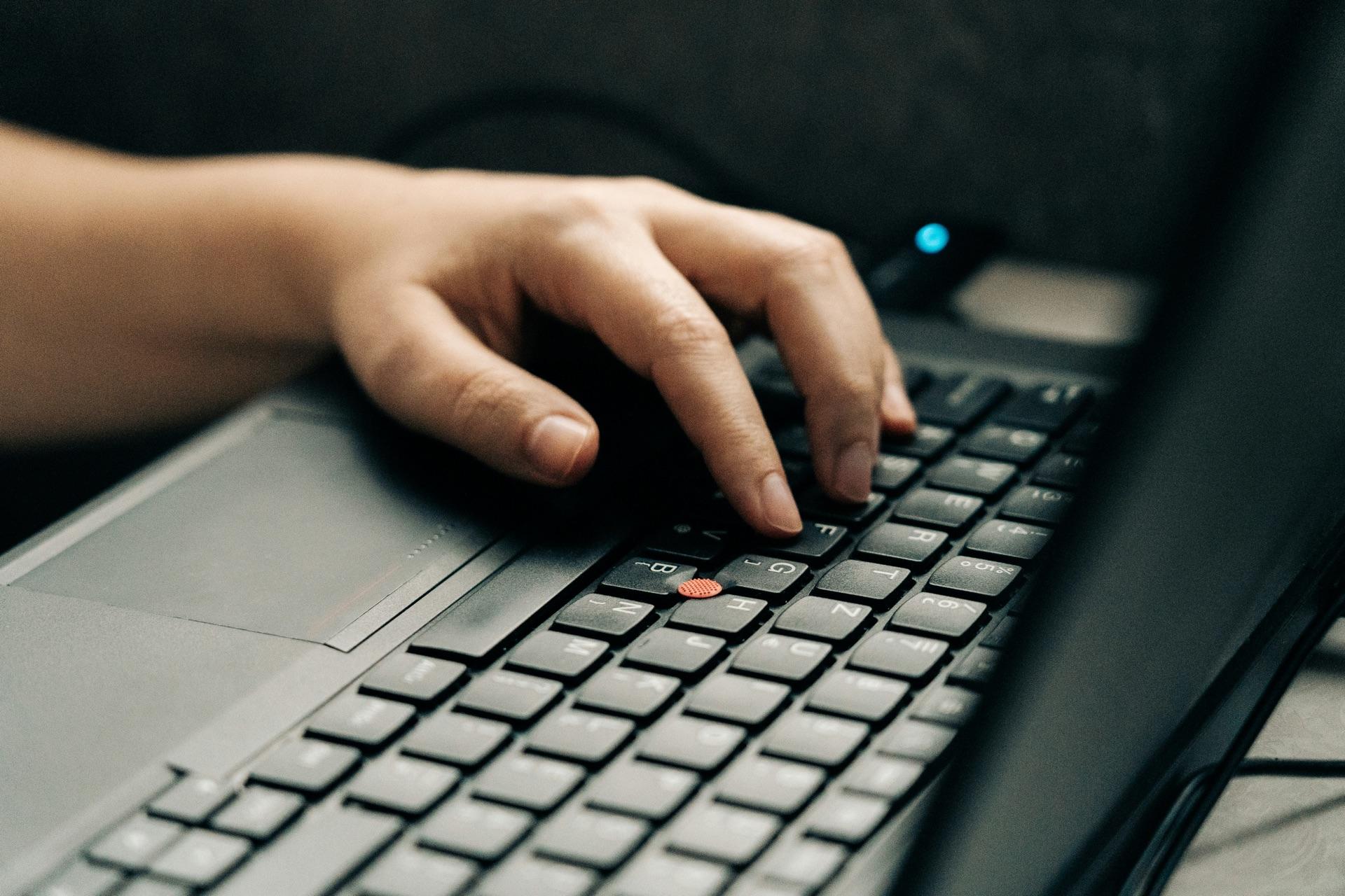 An IT professional working on a laptop to manage network infrastructure