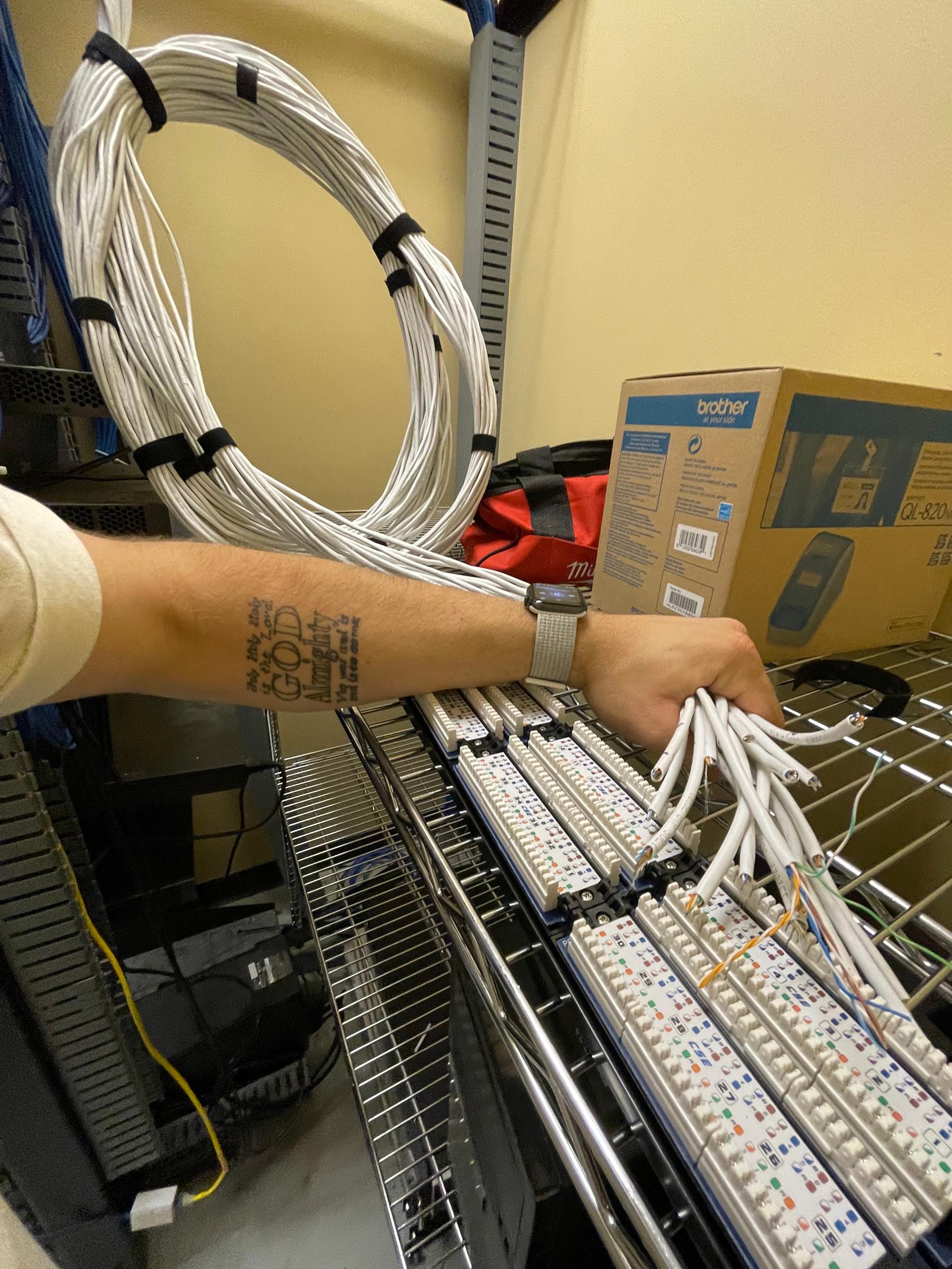 Kenton Batson terminating network cable into a patch panel by hand