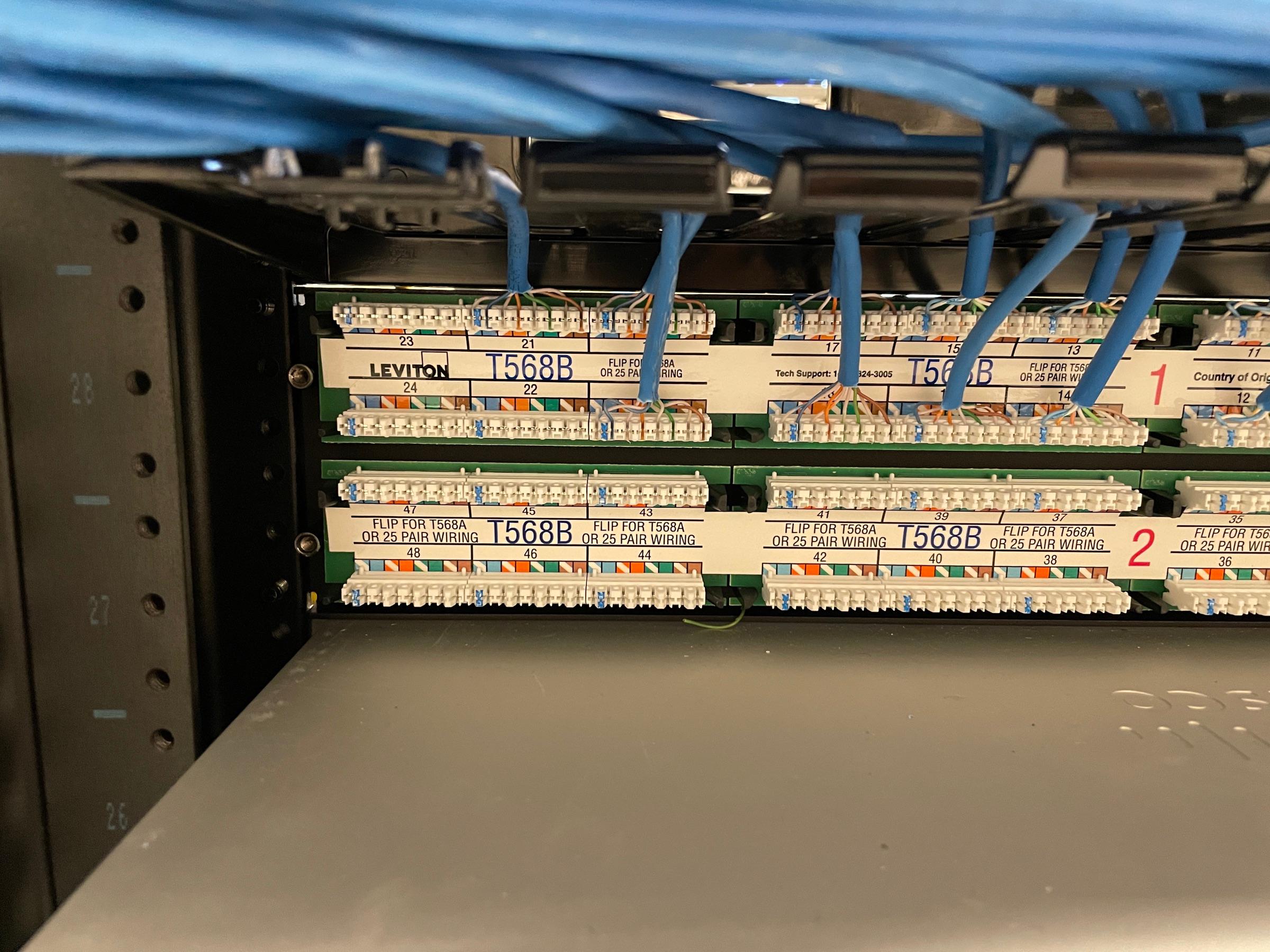 A patch panel with blue network cables terminated by FinWell
