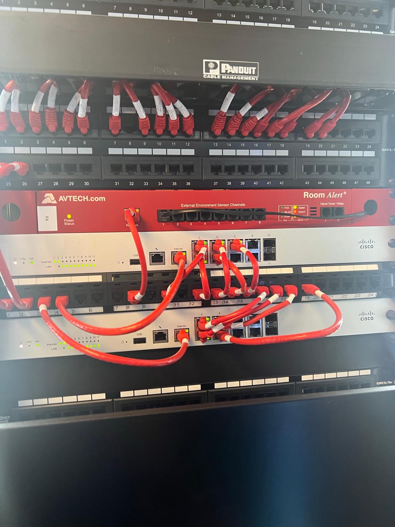 A technician servicing equipment in a network and security equipment closet